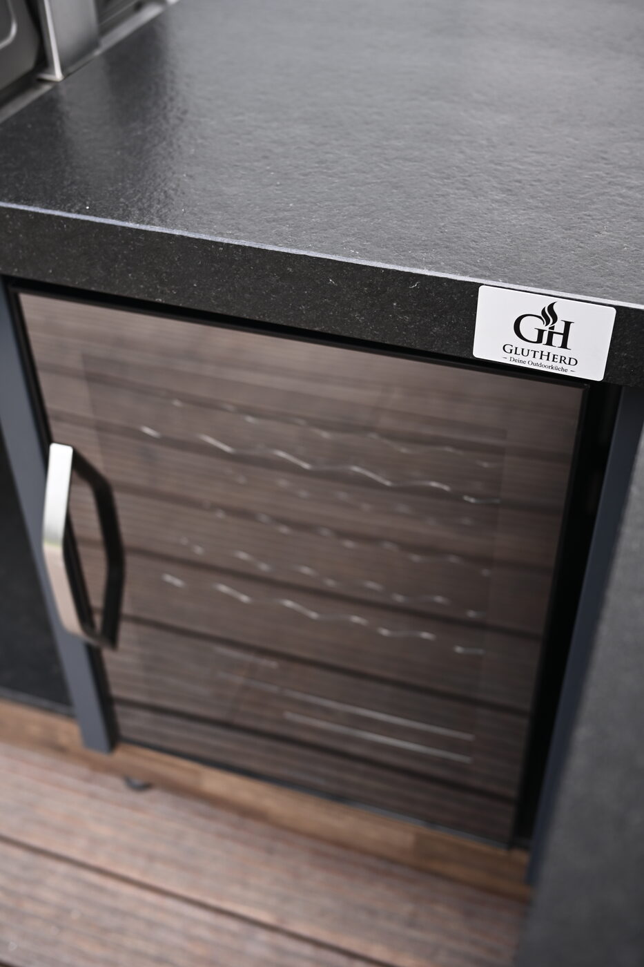 Holzfront der Outdoor-Küche mit GlutHerd-Logo