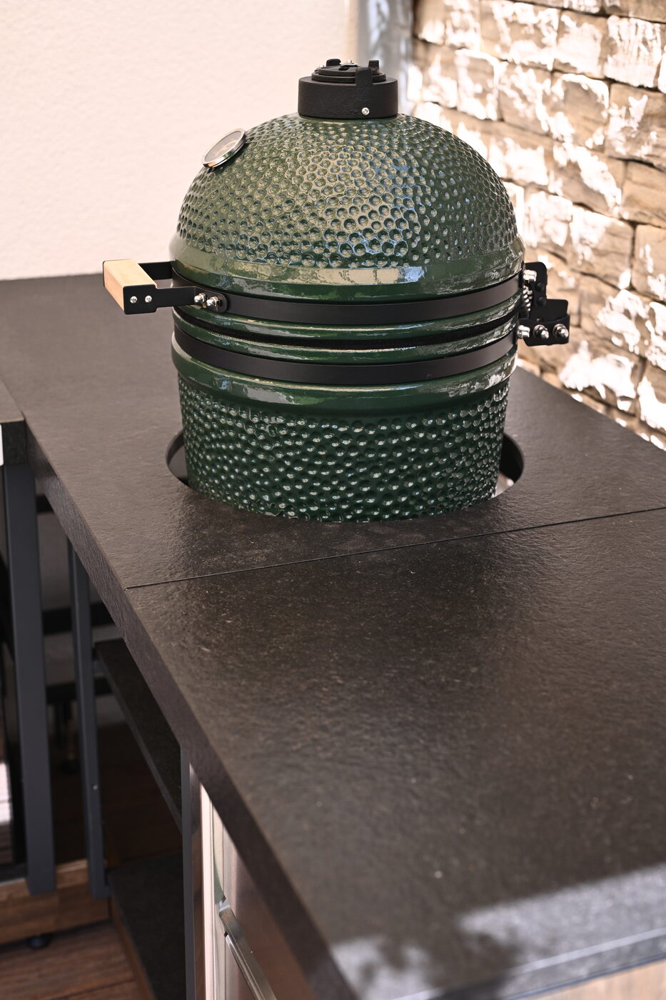 Big Green Egg vor Steinwand auf dem Korpus der Outdoor-Küche