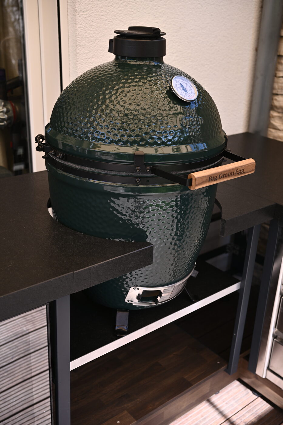 Big Green Egg auf dem dunklen Korpus der Outdoor-Küche